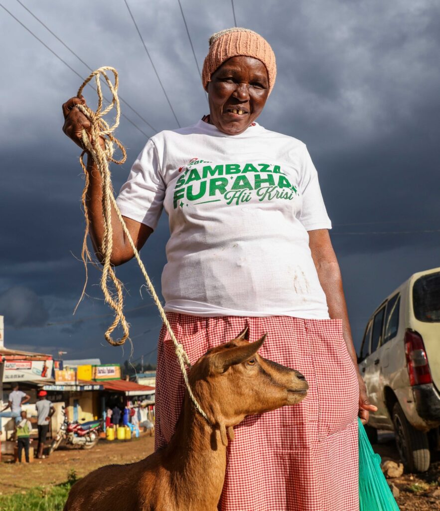 Sally Tembur, a Kapsoit resident and Safaricom customer full of joy after winning a goat courtesy of the ongoing Safaricom Sambaza Furaha campaign at Kapsoit Market in Kericho County. The campaign seeks to delight customers across the country with gifts during this festive season.